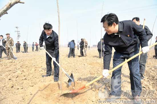 圖為康志民、王春利同黨員志愿者一起參加義務植樹活動。 記者 永翔 攝